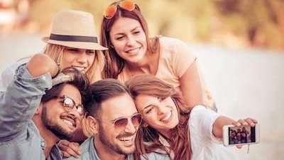 Group of friends in Troy NY broadly smiling with their white teeth