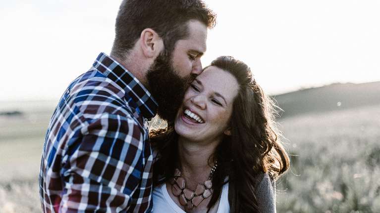A man gently kisses a woman on her cheek